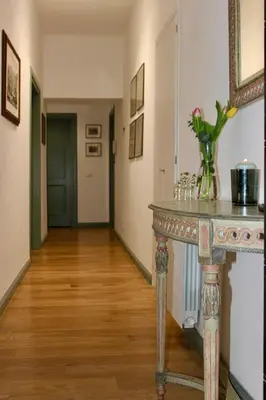 a hallway with a table with a vase of flowers on it at Hideaway 65 - Home by St Peter's in Rome