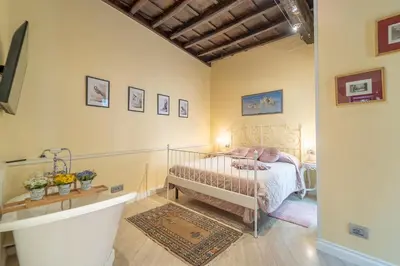 a bedroom with a bed and a tub in it at Secret Luxury Retreat in the Heart of the Ghetto by Houseeds in Rome