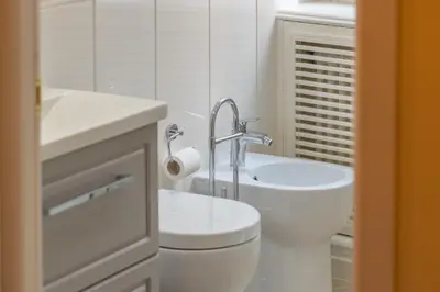 a white bathroom with a toilet and a sink at Secret Luxury Retreat in the Heart of the Ghetto by Houseeds in Rome