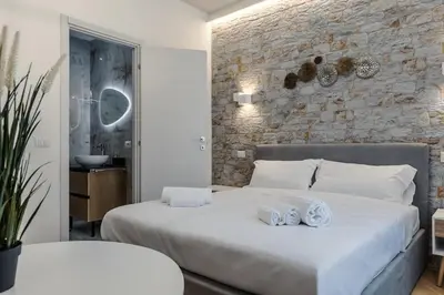 a bedroom with two beds and a stone wall at Hadrian's House in Rome