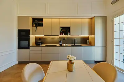 a kitchen with white cabinets and a table and chairs at Residenza Alferini - San Pietro in Rome
