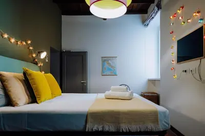 a bedroom with a bed with yellow pillows and lights at Navona Boutique Apartment with terrace in Rome