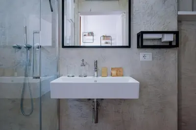 a bathroom with a white sink and a shower at Navona Boutique Apartment with terrace in Rome