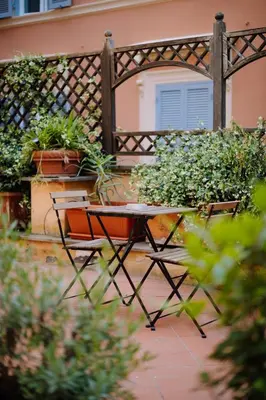 a table and chairs in a garden with a fence at Navona Boutique Apartment with terrace in Rome
