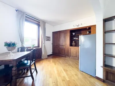 a kitchen and dining room with a table and a refrigerator at Maison Giulia in Rome