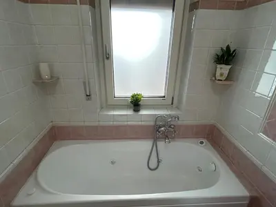 a bath tub with a window and a plant in it at Green house - appartamento rome in Rome