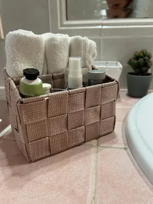 a basket with towels and other items on a bathroom counter at Green house - appartamento rome in Rome