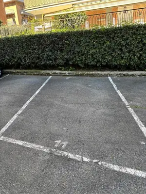 a parking lot with white lines in front of a building at Green house - appartamento rome in Rome