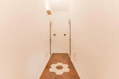 a hallway with a door and a tile floor at Domina Livia Vaticano Roma - Suite e Room in Rome