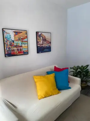 a white couch with four colorful pillows on it at Domus Pacis in Rome