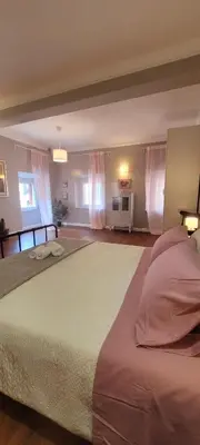 a large bed in a bedroom with pink curtains at Suite Benedict Pantheon in Rome