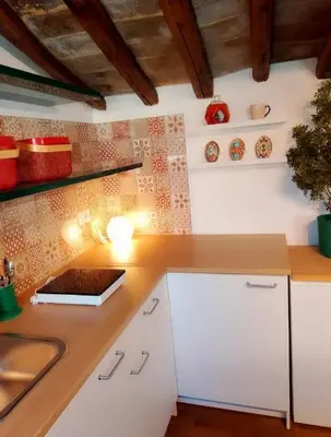 a kitchen with white cabinets and a counter top at Suite Benedict Pantheon in Rome