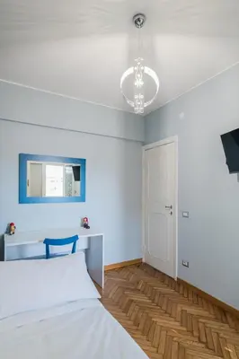 a bedroom with a white bed and a blue wall at B&B Damagi in Rome