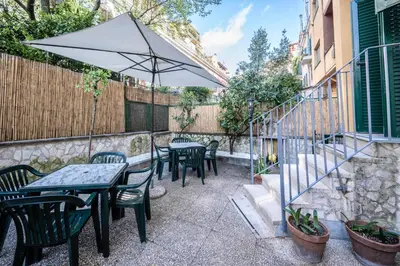 a patio with tables and chairs and an umbrella at Exquilia Home & Garden at the Colosseum in Rome
