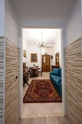 a living room with a blue couch and a table at Exquilia Home & Garden at the Colosseum in Rome