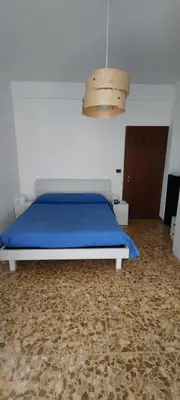 a bedroom with a bed with blue sheets and a light at Casa con Lorenzo in Rome