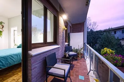 a balcony with chairs and a bed and a window at 3 Passi Da Metro Marconi- 8 min Colosseo in Rome