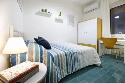a bedroom with a bed with blue pillows on it at 3 Passi Da Metro Marconi- 8 min Colosseo in Rome