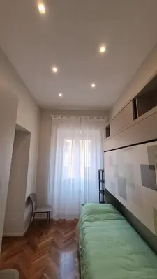 a bedroom with a green bed and a window at Jolegrè all'Opera in Rome