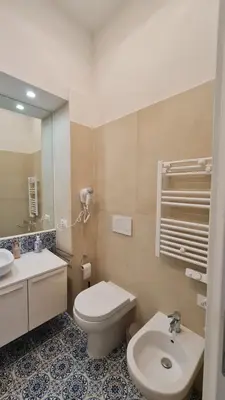 a bathroom with a toilet and a sink and a mirror at Jolegrè all'Opera in Rome