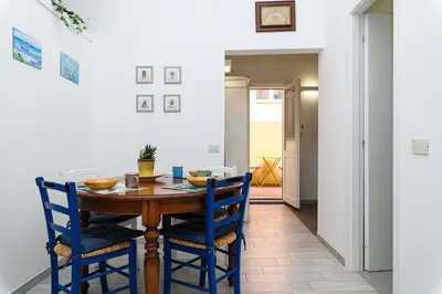 a dining room with a wooden table and blue chairs at La Casina di Luigi con balcone in Rome