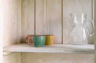 a shelf with three cups and a glass vase at La Casina di Luigi con balcone in Rome
