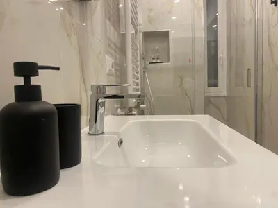 a bathroom with a sink and a black soap dispenser at Talamo Heritage in Rome