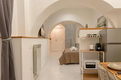 a kitchen with an archway and a room with a bed at casa cavour in Rome