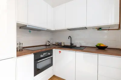 a white kitchen with white cabinets and a stove at NOSTROMONDO San Cosimato Trastevere Place in Rome