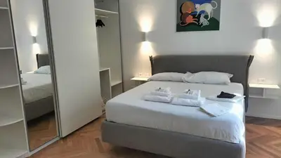 a bedroom with a white bed with a mirror at Catone 34 in Rome