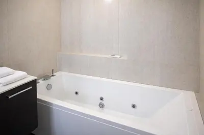 a white bath tub in a bathroom with a mirror at Luxury Stay in Rome Steps from Metro A Cornelia in Rome