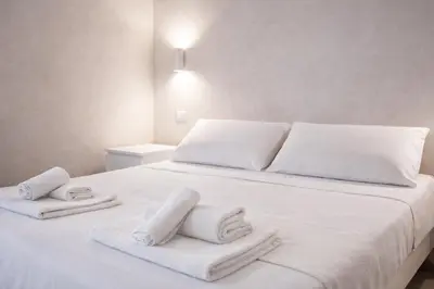 a white bed with towels on top of it at Luxury Stay in Rome Steps from Metro A Cornelia in Rome