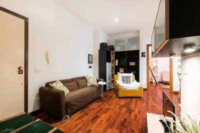a living room with a couch and wooden floors at Design Apartment close to Trastevere in Rome