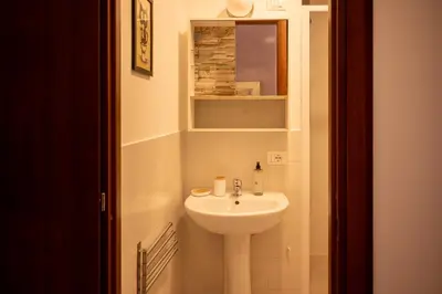 a bathroom with a white sink and a mirror at Sanlorenzo MaDa House in Rome