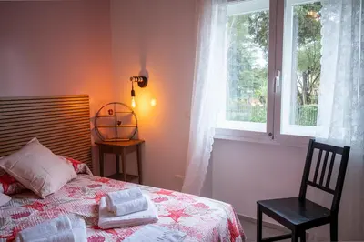 a bedroom with a bed and a chair and a window at Sanlorenzo MaDa House in Rome