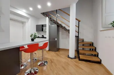 a kitchen with a counter and a staircase in a room at Trevi Suite Apartment - Barberini in Rome