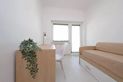 a bedroom with a bed and a desk with a plant at Attico di Design a Garbatella con Vista San Pietro in Rome