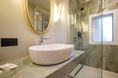 a bathroom with a sink and a mirror at Bocca di Leone Luxury Suite in Rome