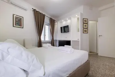 a white bedroom with a large bed and a fireplace at Pantheon Charming by Varental in Rome