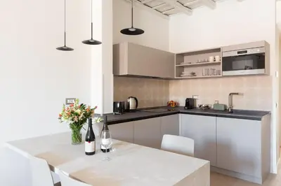a kitchen with white cabinets and a table with flowers at Residenza Foraggi 83 in Rome