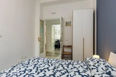 a bedroom with a bed with a blue and white comforter at Giuliana Apartment Vatican in Rome