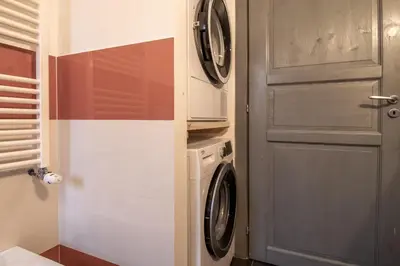 a laundry room with a washer and dryer next to a door at Suite Color Family Roma in Rome