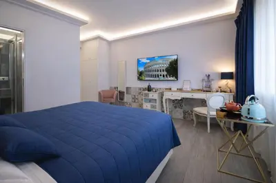 a bedroom with a blue bed and a desk at RomAntic Dreams Guest House in Rome