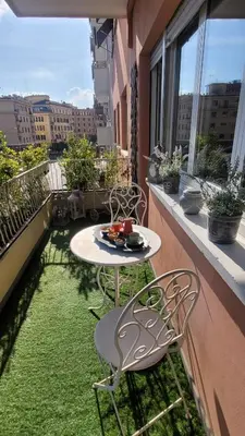 a balcony with a table and chairs on the grass at RomAntic Dreams Guest House in Rome
