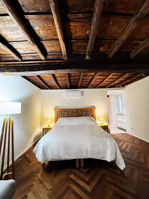 a bedroom with a large bed and wooden ceilings at Navona Fox House 1 in Rome