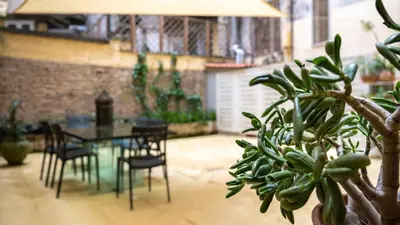 a patio with a table and chairs and a plant at Domus Oro nel cuore di Roma in Rome