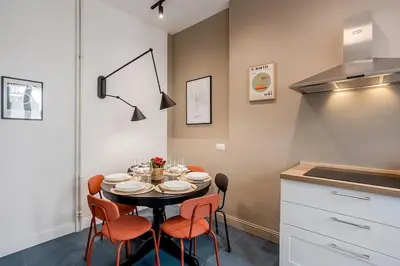 a dining room with a table and chairs in a kitchen at Flowers Apartment - grande casa a Montesacro in Rome