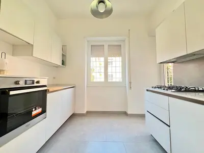 a kitchen with white cabinets and a stove top oven at L'Oasi di Ale in Rome