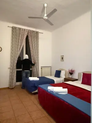 a person opening a window in a hotel room at Niam House Volturno in Rome