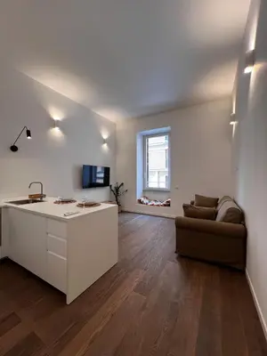 a living room with a kitchen and a couch at Carlo Alberto Suite in Rome